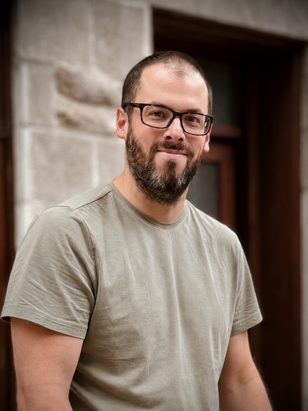 Portrait of Lawrence Leroux wearing glasses and a grey T-shirt