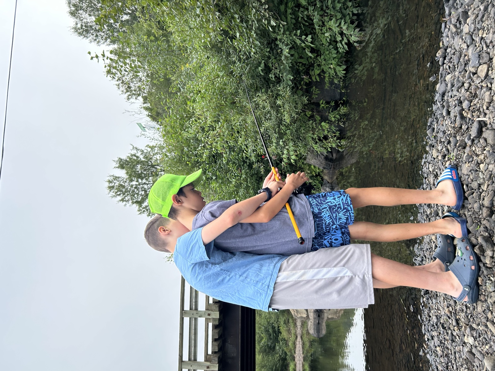 Lawrence’s two older children fishing together beside the water